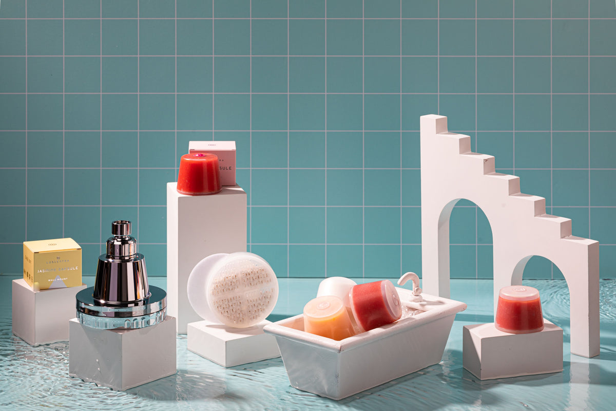 Luscentra shower filters and colorful capsules in a blue-tile product display.