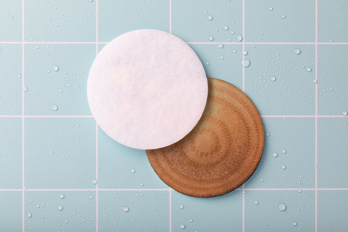 A clean white microfibre filter alongside a brown used microfibre filter.