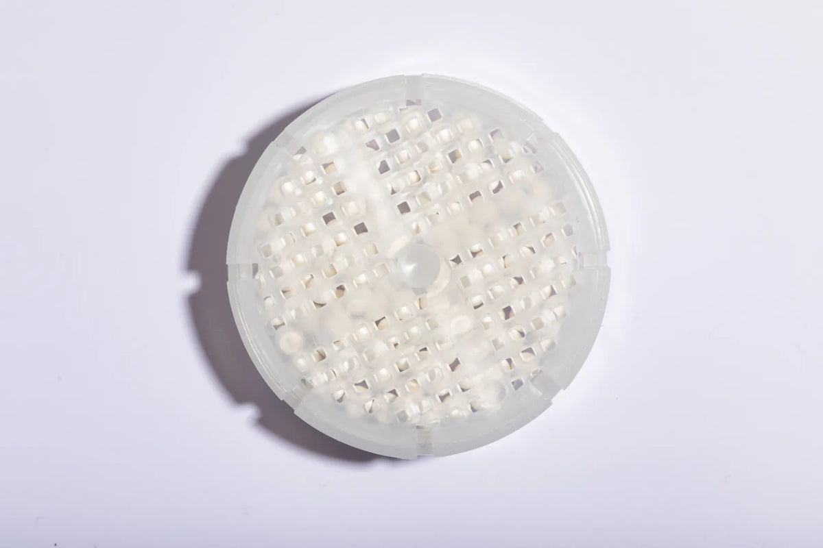 Luscentra antibacterial ceramic shower-filter balls on blue tile.
