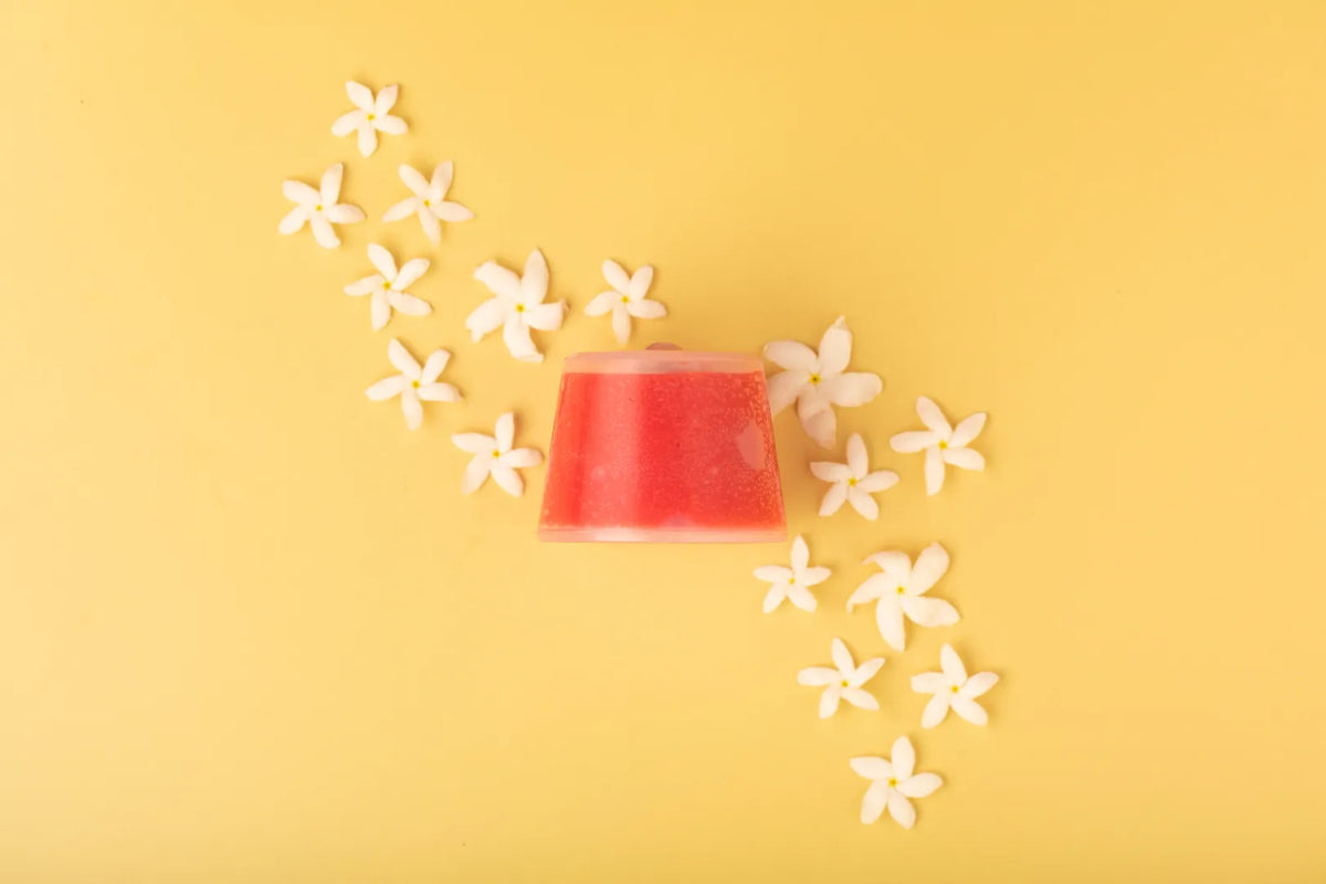 Luscentra jasmine vitamin C capsule with jasmine flowers on yellow.