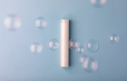 Neutral Luscentra vitamin C shower capsule surrounded by bubbles.