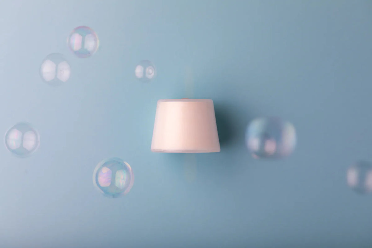 Neutral Luscentra vitamin C shower capsule surrounded by bubbles.
