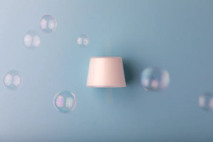Neutral Luscentra vitamin C shower capsule surrounded by bubbles.