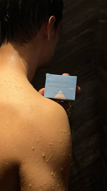 Person holding a Luscentra vitamin C shower-capsule package.