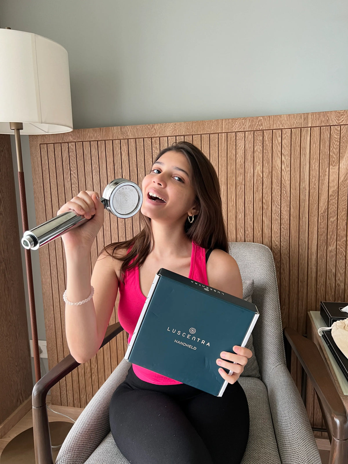 Woman presenting a black Luscentra starter-kit box.