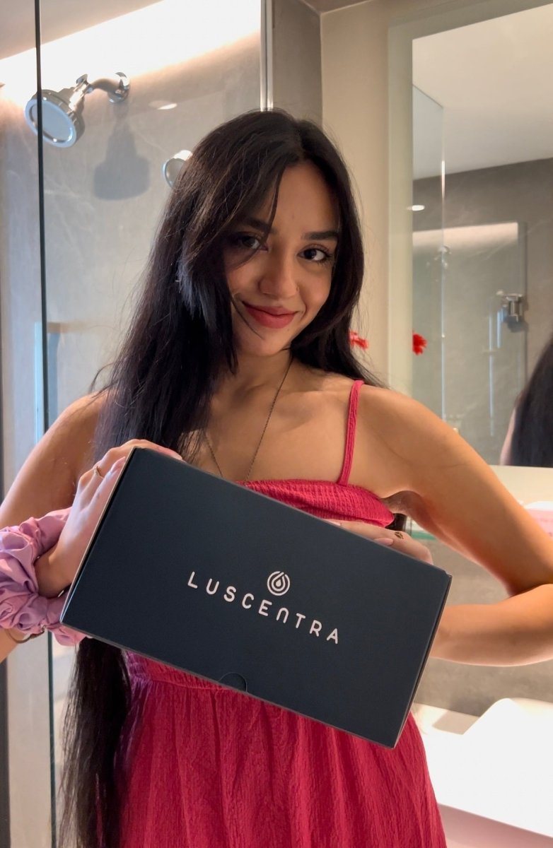 Woman presenting a black Luscentra starter-kit box.