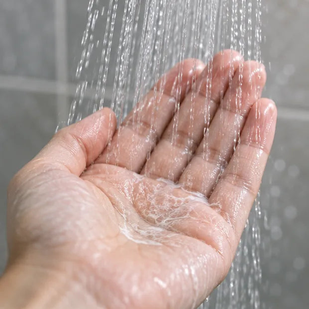 A hand beneath clear running water.