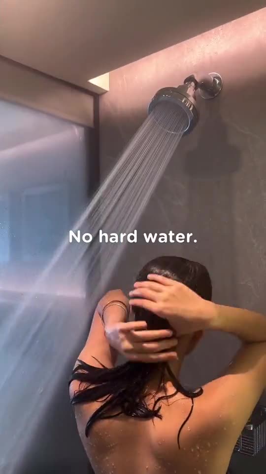 A woman rinsing her hair under a Luscentra wall-mount showerhead